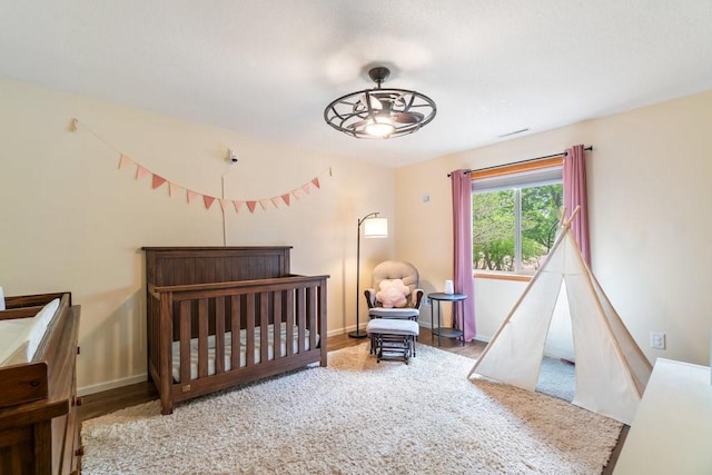 3829 Nicholas Dr, Menomonie, WI 54751 - bedroom featuring a nursery area, wood finished floors, and baseboards