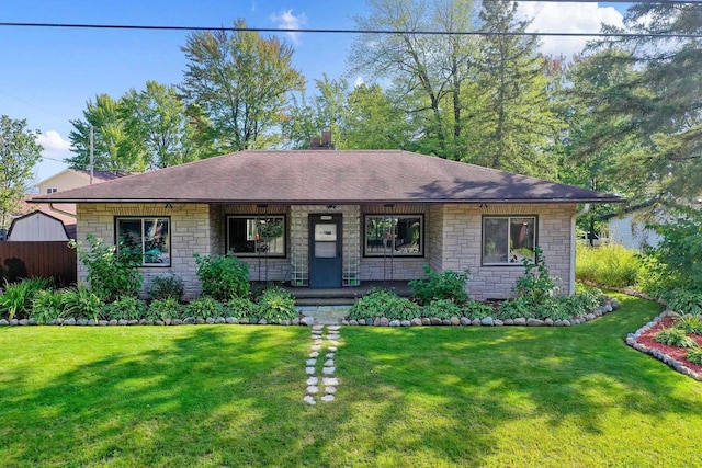 W6023 Lake Dr, Shawano, WI 54166 - ranch-style home with stone siding, a porch, a front yard, and roof with shingles