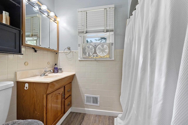 W6023 Lake Dr, Shawano, WI 54166 - full bathroom featuring tile walls, wood finished floors, toilet, a shower with curtain, and vanity