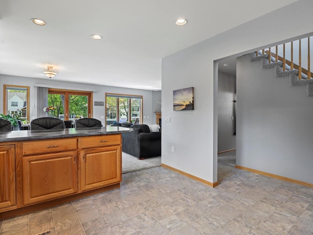 1306 Neponset Trl, Monona, WI 53716 - kitchen with dark countertops, baseboards, recessed lighting, open floor plan, and brown cabinets