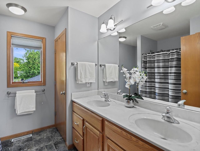 1306 Neponset Trl, Monona, WI 53716 - full bath with double vanity, baseboards, and stone finish floors