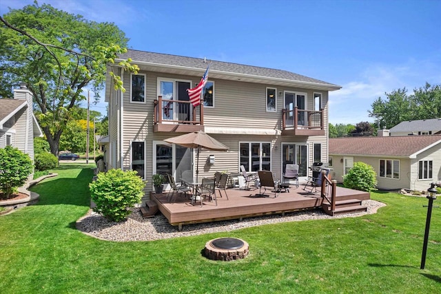 1306 Neponset Trl, Monona, WI 53716 - back of house with a balcony, an outdoor fire pit, a lawn, outdoor dining area, and a deck