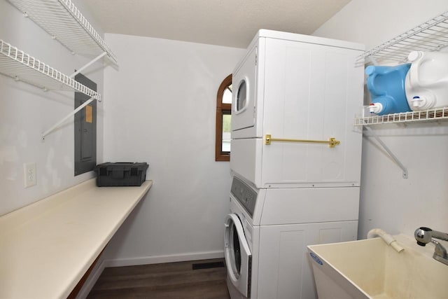 2462 Wallace Lake Rd, West Bend, WI 53090 - washroom with stacked washer and clothes dryer, dark wood finished floors, electric panel, and baseboards