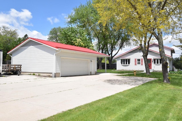 2462 Wallace Lake Rd, West Bend, WI 53090 - view of home's exterior with a lawn, an outbuilding, a detached garage, and metal roof