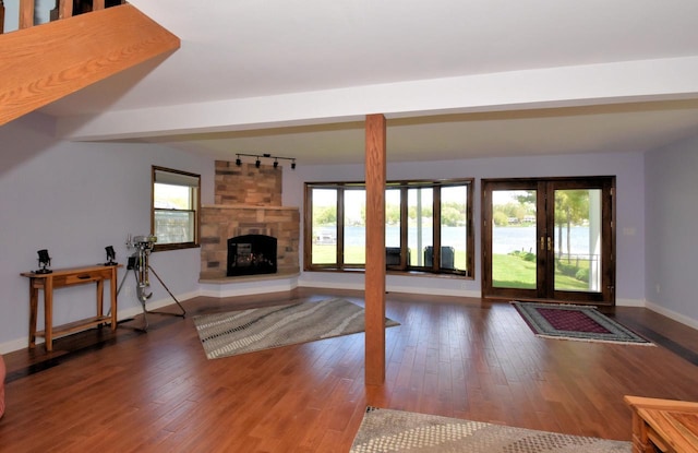 2462 Wallace Lake Rd, West Bend, WI 53090 - unfurnished living room featuring wood finished floors, baseboards, rail lighting, and a fireplace