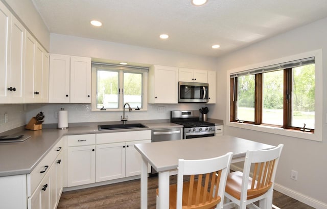 2462 Wallace Lake Rd, West Bend, WI 53090 - kitchen with stainless steel appliances, a sink, dark wood-style floors, decorative backsplash, and recessed lighting