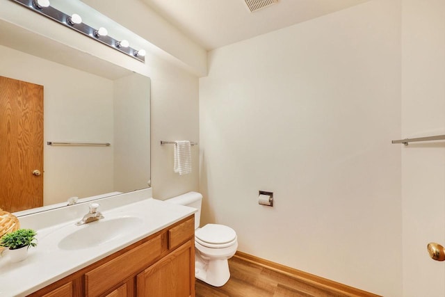 6911 Raymond Rd, Madison, WI 53711 - half bath featuring toilet, vanity, wood finished floors, and baseboards
