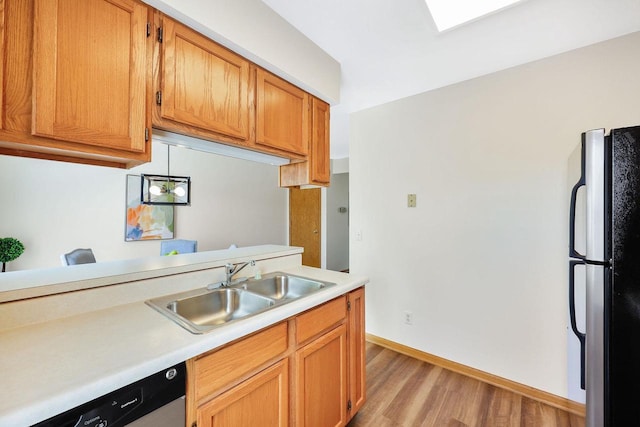 6911 Raymond Rd, Madison, WI 53711 - kitchen with freestanding refrigerator, a sink, light countertops, light wood-type flooring, and dishwasher