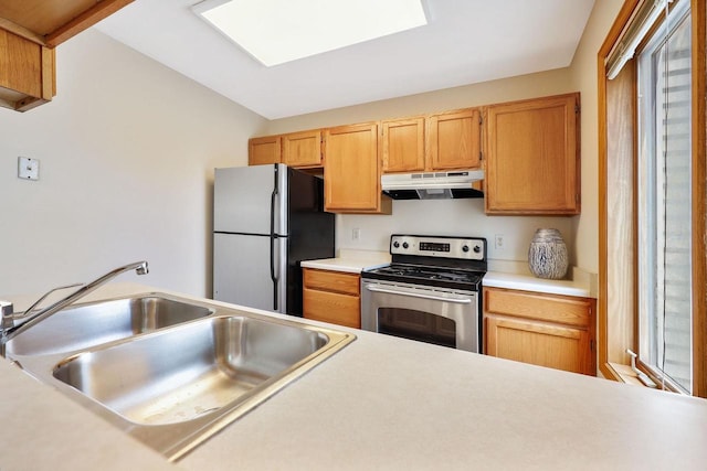 6911 Raymond Rd, Madison, WI 53711 - kitchen with stainless steel electric range oven, under cabinet range hood, freestanding refrigerator, a sink, and light countertops