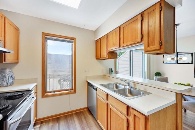 6911 Raymond Rd, Madison, WI 53711 - kitchen featuring stainless steel appliances, light wood finished floors, a sink, light countertops, and a peninsula