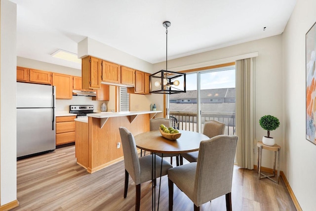 6911 Raymond Rd, Madison, WI 53711 - dining area featuring a chandelier, light wood finished floors, and baseboards