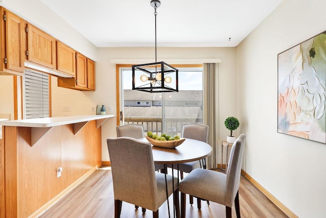 6911 Raymond Rd, Madison, WI 53711 - dining space featuring light wood-type flooring, baseboards, and a chandelier