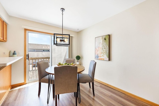 6911 Raymond Rd, Madison, WI 53711 - dining area featuring light wood-type flooring, baseboards, and a chandelier