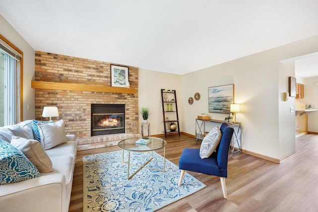 6911 Raymond Rd, Madison, WI 53711 - living room with wood finished floors, baseboards, and a brick fireplace