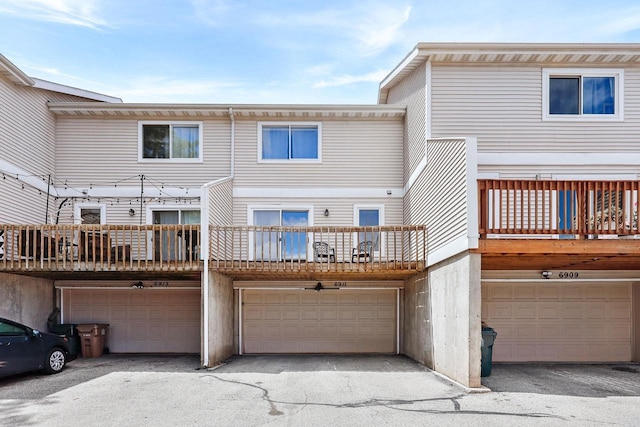 6911 Raymond Rd, Madison, WI 53711 - back of property featuring a garage, driveway, and a balcony