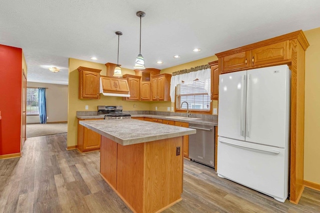 618 Little Fawn Dr, Nekoosa, WI 54457 - kitchen with stainless steel appliances, a sink, a kitchen island, light countertops, and light wood finished floors