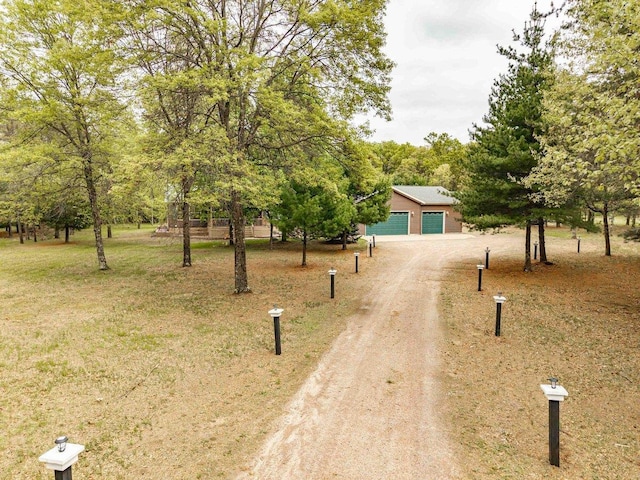 618 Little Fawn Dr, Nekoosa, WI 54457 - obstructed view of property featuring an outbuilding, a detached garage, and dirt driveway