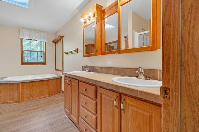 618 Little Fawn Dr, Nekoosa, WI 54457 - bathroom featuring wood finished floors, a garden tub, double vanity, and a shower with door
