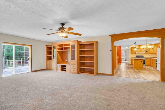 618 Little Fawn Dr, Nekoosa, WI 54457 - unfurnished living room featuring light colored carpet, a chandelier, a ceiling fan, baseboards, and a textured ceiling