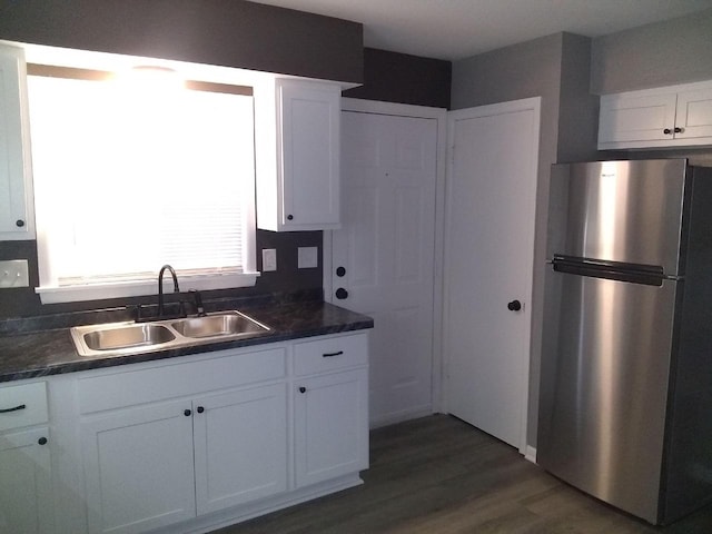 8594 W Villard Ave, Milwaukee, WI 53225 - kitchen with freestanding refrigerator, a sink, dark countertops, white cabinets, and dark wood-type flooring