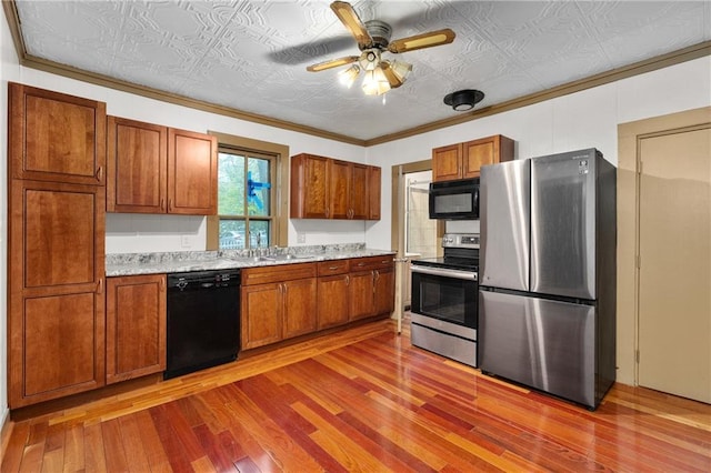 1020 E 10th St, Menomonie, WI 54751 - kitchen with black appliances, an ornate ceiling, brown cabinets, wood finished floors, and light countertops