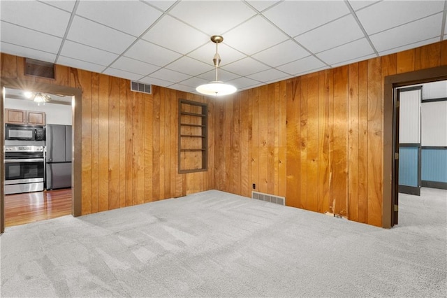 1020 E 10th St, Menomonie, WI 54751 - empty room with carpet flooring, wooden walls, and a drop ceiling