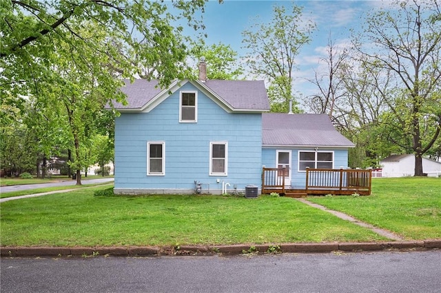 1020 E 10th St, Menomonie, WI 54751 - view of front of house featuring a wooden deck, a chimney, a front lawn, and cooling unit
