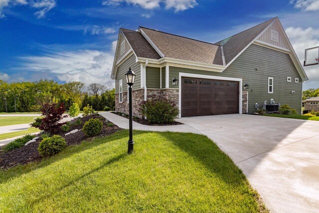 W239N7521 High Ridge Dr, Sussex, WI 53089 - view of property exterior featuring driveway, a yard, roof with shingles, a garage, and stone siding