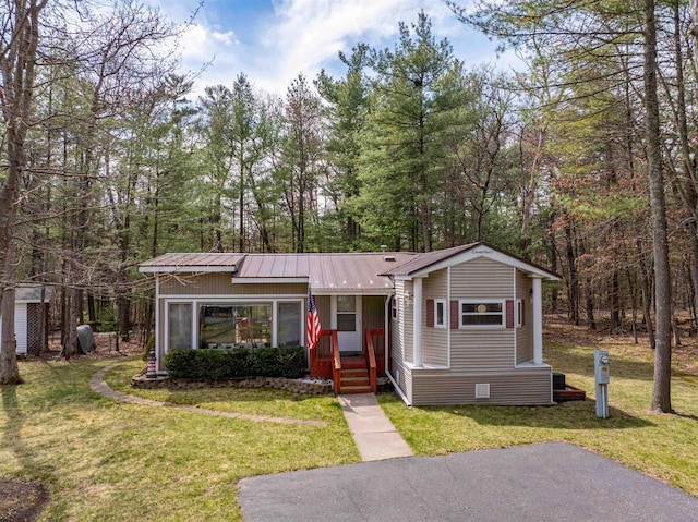 134 Glen View Dr Unit 44, Wisconsin Dells, WI 53965 - view of front of house featuring a front lawn, metal roof, and a wooded view
