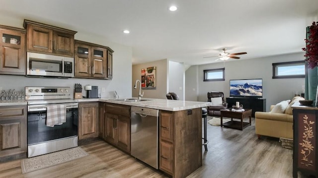 20170 63rd Ave, Chippewa Falls, WI 54729 - kitchen featuring appliances with stainless steel finishes, a sink, a peninsula, open floor plan, and light wood-style flooring