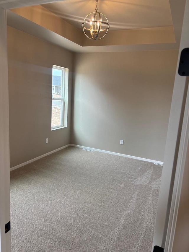 1236 Northwood Dr, Seymour, WI 54165 - carpeted spare room with a chandelier, a tray ceiling, and baseboards