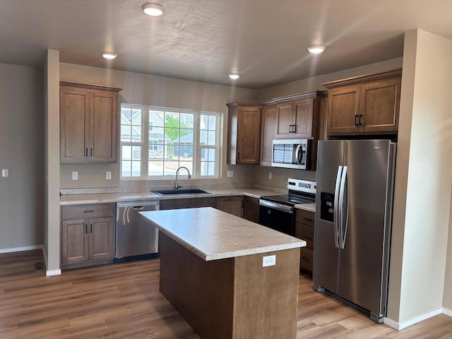 1236 Northwood Dr, Seymour, WI 54165 - kitchen featuring stainless steel appliances, a sink, wood finished floors, light countertops, and a kitchen island