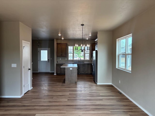 1236 Northwood Dr, Seymour, WI 54165 - kitchen with a sink, freestanding refrigerator, a chandelier, a kitchen island, and light countertops