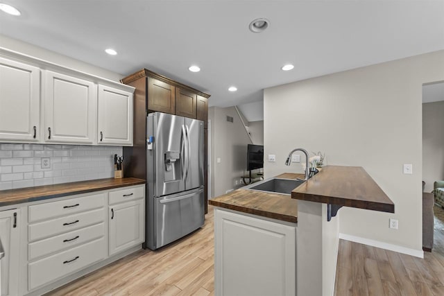 5806 E Open Mdw, Mcfarland, WI 53558 - kitchen with butcher block countertops, stainless steel fridge, a sink, light wood finished floors, and backsplash