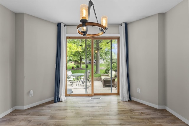 5806 E Open Mdw, Mcfarland, WI 53558 - unfurnished dining area featuring a chandelier, wood finished floors, and baseboards