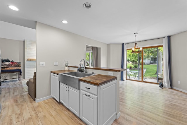 5806 E Open Mdw, Mcfarland, WI 53558 - kitchen featuring wood counters, a peninsula, white dishwasher, light wood finished floors, and recessed lighting