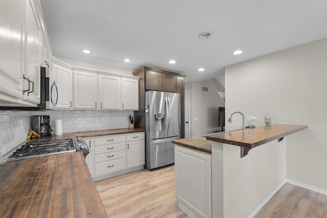 5806 E Open Mdw, Mcfarland, WI 53558 - kitchen with wood counters, stainless steel appliances, light wood-style flooring, decorative backsplash, and recessed lighting
