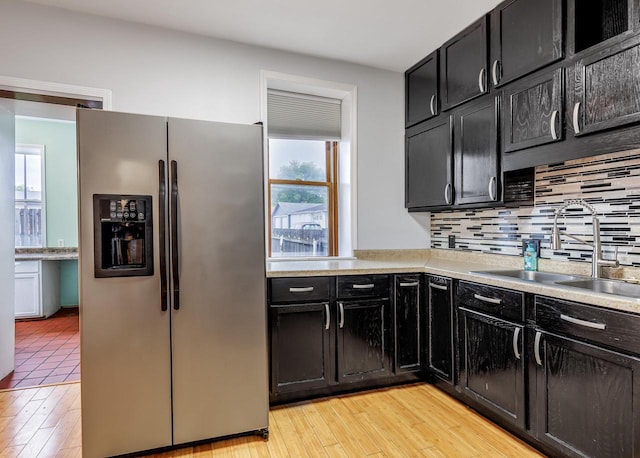 415 Ferry St, La Crosse, WI 54601 - kitchen featuring stainless steel refrigerator with ice dispenser, a sink, dark cabinets, and backsplash