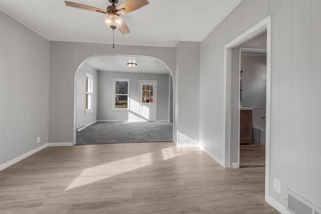924 N Stevens St, Rhinelander, WI 54501 - unfurnished dining area featuring arched walkways, ceiling fan, wood finished floors, and baseboards
