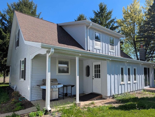 N79W33915 Petersen Rd, Oconomowoc, WI 53066 - view of front facade featuring board and batten siding, roof with shingles, and a chimney