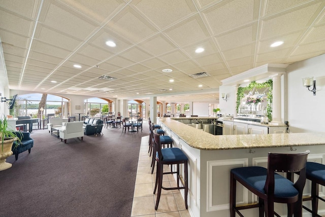 335 Wrigley Dr Unit 411, Lake Geneva, WI 53147 - kitchen with a kitchen breakfast bar, recessed lighting, light stone countertops, open floor plan, and decorative columns