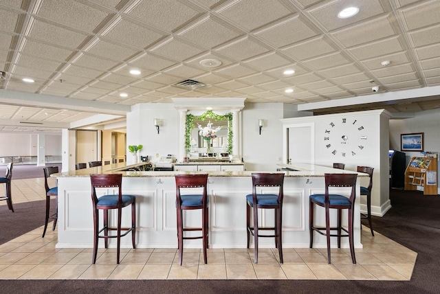 335 Wrigley Dr Unit 411, Lake Geneva, WI 53147 - kitchen with recessed lighting, a breakfast bar, a peninsula, light stone countertops, and light tile patterned flooring