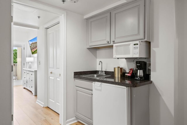 335 Wrigley Dr Unit 411, Lake Geneva, WI 53147 - indoor wet bar featuring white microwave and light wood-type flooring