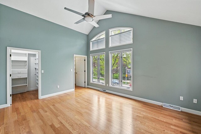 1420 N Astor St, Milwaukee, WI 53202 - unfurnished bedroom with high vaulted ceiling, light wood-style floors, baseboards, a walk in closet, and ceiling fan