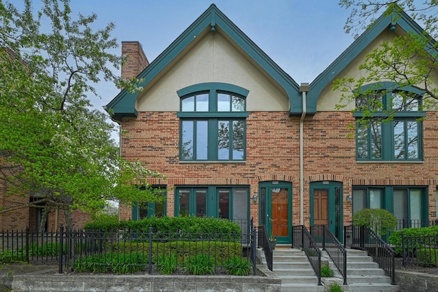 1420 N Astor St, Milwaukee, WI 53202 - view of front facade featuring a chimney, stucco siding, and brick siding