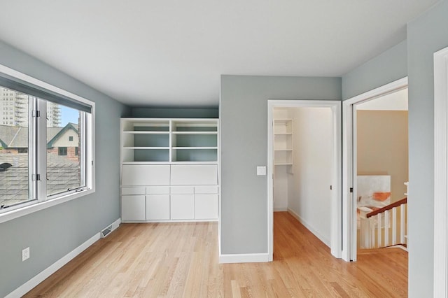 1420 N Astor St, Milwaukee, WI 53202 - unfurnished bedroom with light wood-style flooring, a walk in closet, baseboards, and a closet