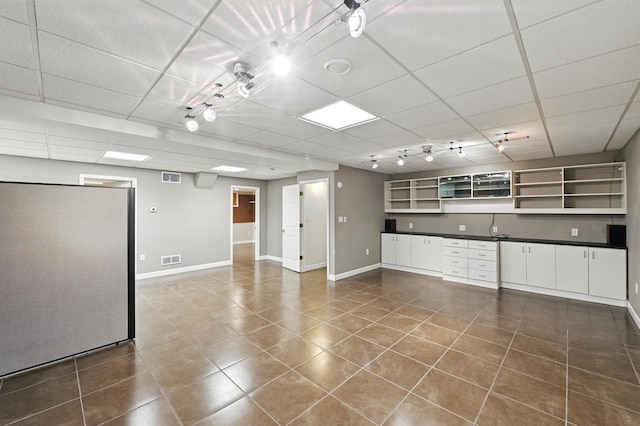 1420 N Astor St, Milwaukee, WI 53202 - empty room featuring a drop ceiling, dark tile patterned floors, and baseboards