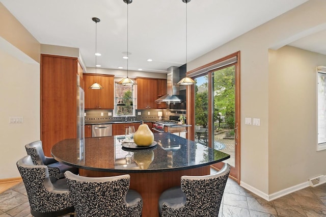 1420 N Astor St, Milwaukee, WI 53202 - kitchen with wall chimney range hood, appliances with stainless steel finishes, plenty of natural light, brown cabinets, and recessed lighting