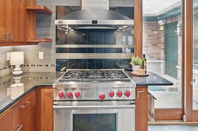 1420 N Astor St, Milwaukee, WI 53202 - kitchen featuring extractor fan, luxury stove, brown cabinetry, decorative backsplash, and dark stone countertops