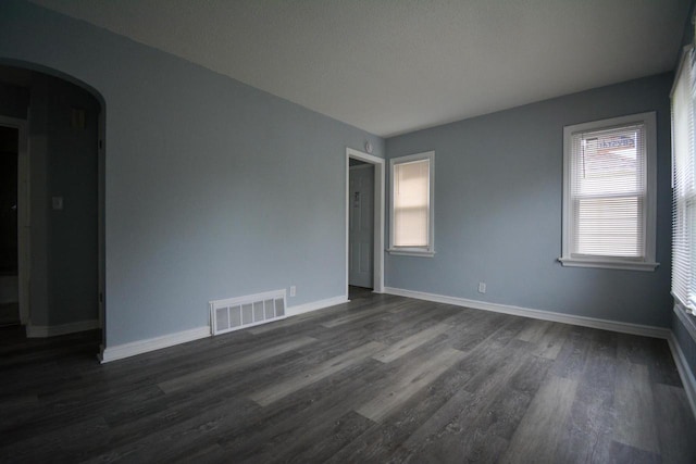 4646 N 51st Blvd, Milwaukee, WI 53218 - unfurnished room with arched walkways, dark wood-type flooring, and baseboards